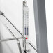 A thermometer on a metal surface attached to a Hatco stainless steel countertop warmer cabinet.