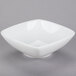 A Tuxton TuxTrendz white square bowl on a gray surface.