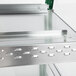 A close-up of a metal shelf with a glass top.