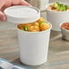 A 16 oz. double poly-coated white paper food cup with a vented paper lid, shown containing food.