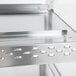 A white granite stainless steel Hatco merchandiser shelf with holes.