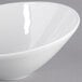 A Tuxton TuxTrendz bright white china bowl with a slanted rim.