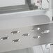 A close-up of a stainless steel Hatco countertop hot food display warmer with metal shelves.