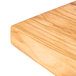 An American Metalcraft olive wood serving board on a wood surface.