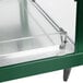 A green and stainless steel Hatco countertop food warmer with glass shelves in a glass display case.