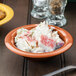A bowl of crab salad in a pumpkin melamine bowl.