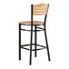 A Lancaster Table & Seating side bar stool with natural wood seat and back and a black frame.