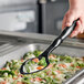 A person serving broccoli and carrots with a black Vollrath nylon spoon.