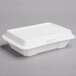 A Dart white foam take out container with a lid.