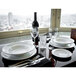 A table set with Tuxton AlumaTux Pearl White china bowls, plates, and glasses.