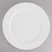 A Tuxton AlumaTux Pearl White china plate with a curved edge.