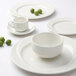 A group of Tuxton AlumaTux Pearl White plates.