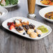 A rectangular white china platter with food on it on a table.