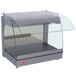 A Hatco gray curved glass food warmer on a countertop with a clear glass cover.