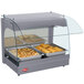 A Hatco Gray Glo-Ray curved countertop food warmer displaying food in pans with glass covers.