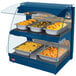 A blue Hatco countertop food warmer with trays of food in a display case with a glass door.