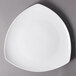 A 10 Strawberry Street Whittier white porcelain triangle salad/dessert plate on a gray surface.