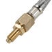 A gold plated brass hose with a brass connector attached to a metal pipe.