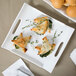 A white rectangular porcelain platter with handles holding food.