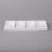 A white rectangular tray with four square dishes inside.