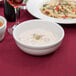 A close-up of Tuxton Alaska bright white china nappie bowl filled with white liquid.