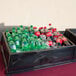 A black Geneva insulated beverage bin on a table with soda bottles and ice.