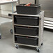 A Lakeside stainless steel utility cart with black bins on top.