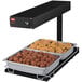 A Hatco heated shelf with trays of food on it.