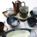 A close up of a black Tuxton china cup with a handle.