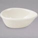 A white Tuxton teardrop ramekin on a gray surface.