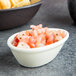 A bowl of salsa with Tuxton eggshell china ramekins filled with tortilla chips.