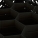 A black Vollrath Traex glass rack with hexagonal compartments.