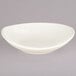 A white Tuxton oval bowl on a gray background.