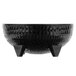 A close-up of a black melamine molcajete bowl with three legs.