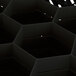 A black plastic Vollrath Traex glass rack with hexagon compartments.