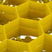 A yellow honeycomb-shaped Vollrath glass rack.