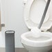 An Unger Ergo toilet bowl swab with white holder in a toilet.