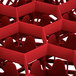 A red Vollrath Traex glass rack with 12 compartments.