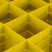 A yellow Vollrath Traex glass rack grid with square compartments and holes.