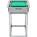 A stainless steel Lakeside tray rack dispenser on a table with a green and white rectangular tray inside.