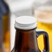 A Libbey beer growler with a white cap on a table.