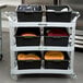 A Lakeside light gray plastic utility cart with black containers and a yellow plate on it.
