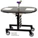 A rectangular maple room service table with a stainless steel frame and black top with a vase of flowers on it.