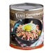 A Vanee #10 can of corned beef hash on a table with a pan of fried corned beef hash and a spoon.