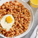 A plate of Vanee corned beef hash with a fried egg on top.