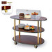 A Geneva 3 tier serving cart with food on it, including a cake.