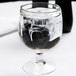 An Arcoroc Amelia stacking goblet filled with ice water on a table.