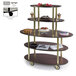 A Geneva oval shelf dessert cart with a glass top holding cakes.