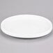 An American Metalcraft Prestige white porcelain plate with a circular rim on a gray surface.