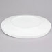 An American Metalcraft Prestige white porcelain plate with a circular rim on a gray surface.